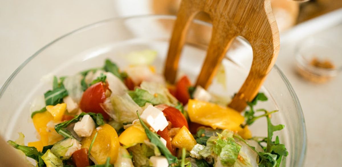 Vibrant vegetable salad with fresh ingredients in a glass bowl, perfect for healthy meals.
