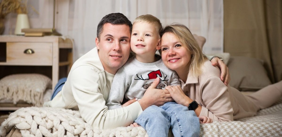 a man and woman with a child on a couch
