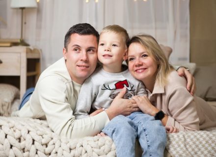 a man and woman with a child on a couch